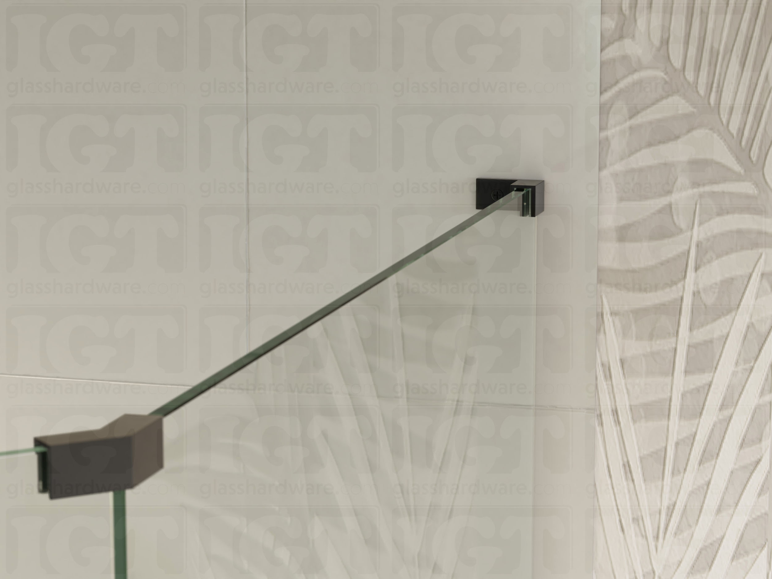 A view of the glass shower enclosure's upper section. The fixed panel is secured to the wall with a Right Wall-to-Glass Sleeve Over Clamp, and joined to an adjacent panel with a glass-to-glass clamp. Matte Black.