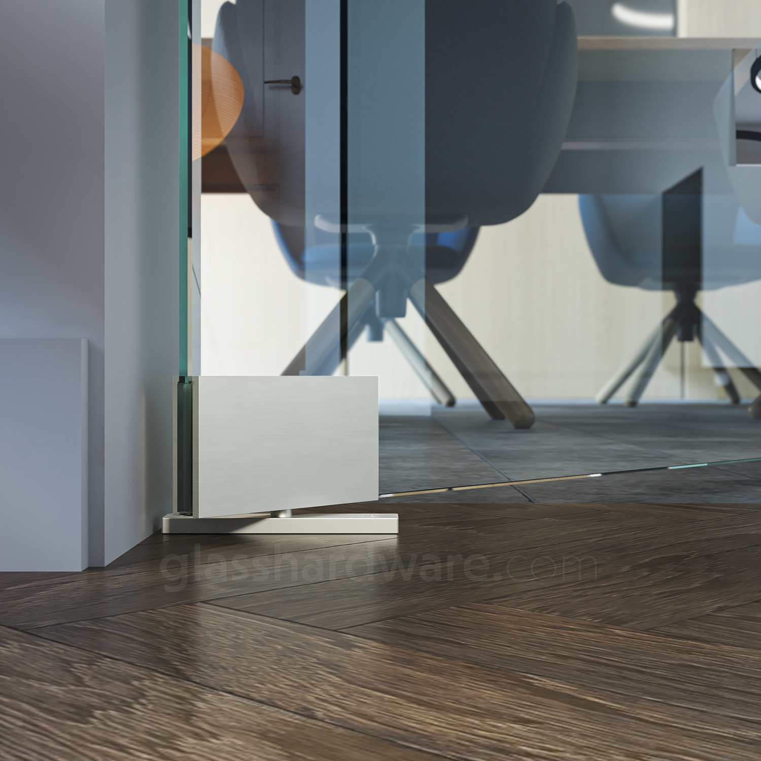 Close-up of the bottom Heavy Duty Top and Bottom Malibu Pivot Hinge installed on a glass door. The base plate is securely fixed to the wooden floor, allowing the hinge to freely pivot.