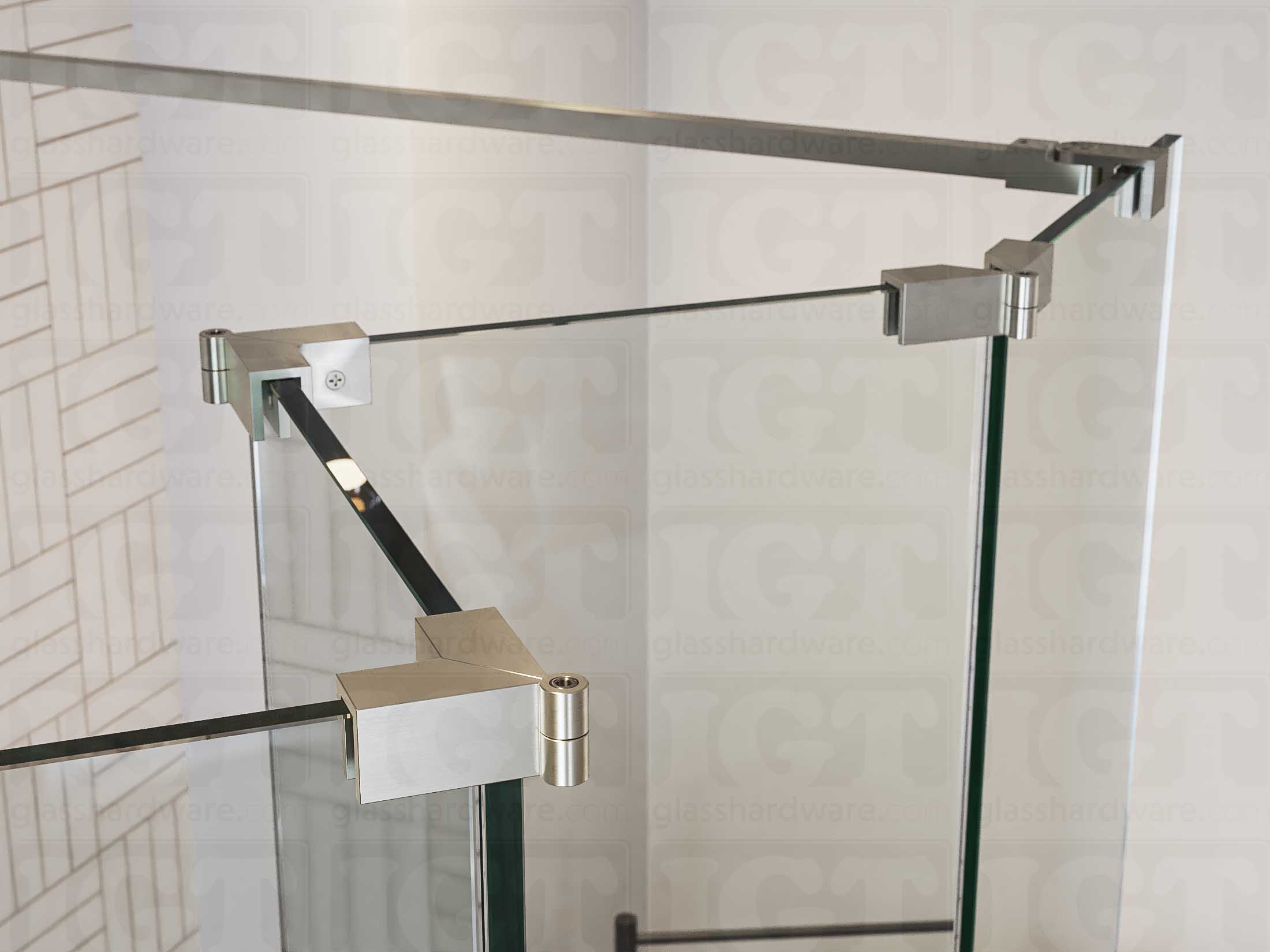 A close up of three Glass-to-Glass Adjustable Sleeve Over Clamps in Brushed Nickel installed on a doorless glass shower enclosure alongside a matching support bar.