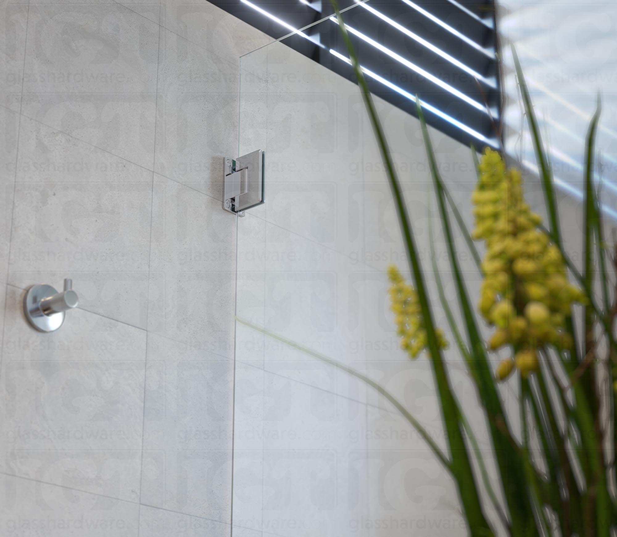 A close-up view from below of the Wall-to-Glass Full Back Bilboa Hinge used in a modern shower door installation. Chrome Polished.