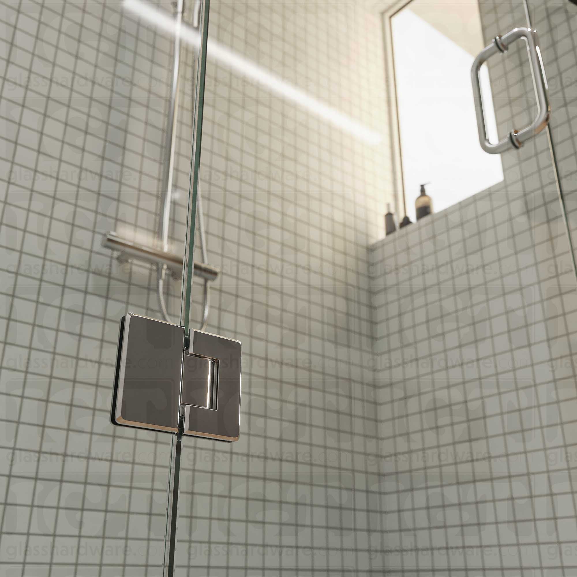 A close-up view of the bottom Glass-to-Glass 180 Degree Bilboa Hinge installed on a modern shower door in the closed position, showcasing its beveled-edge design in more detail. Chrome Polished.