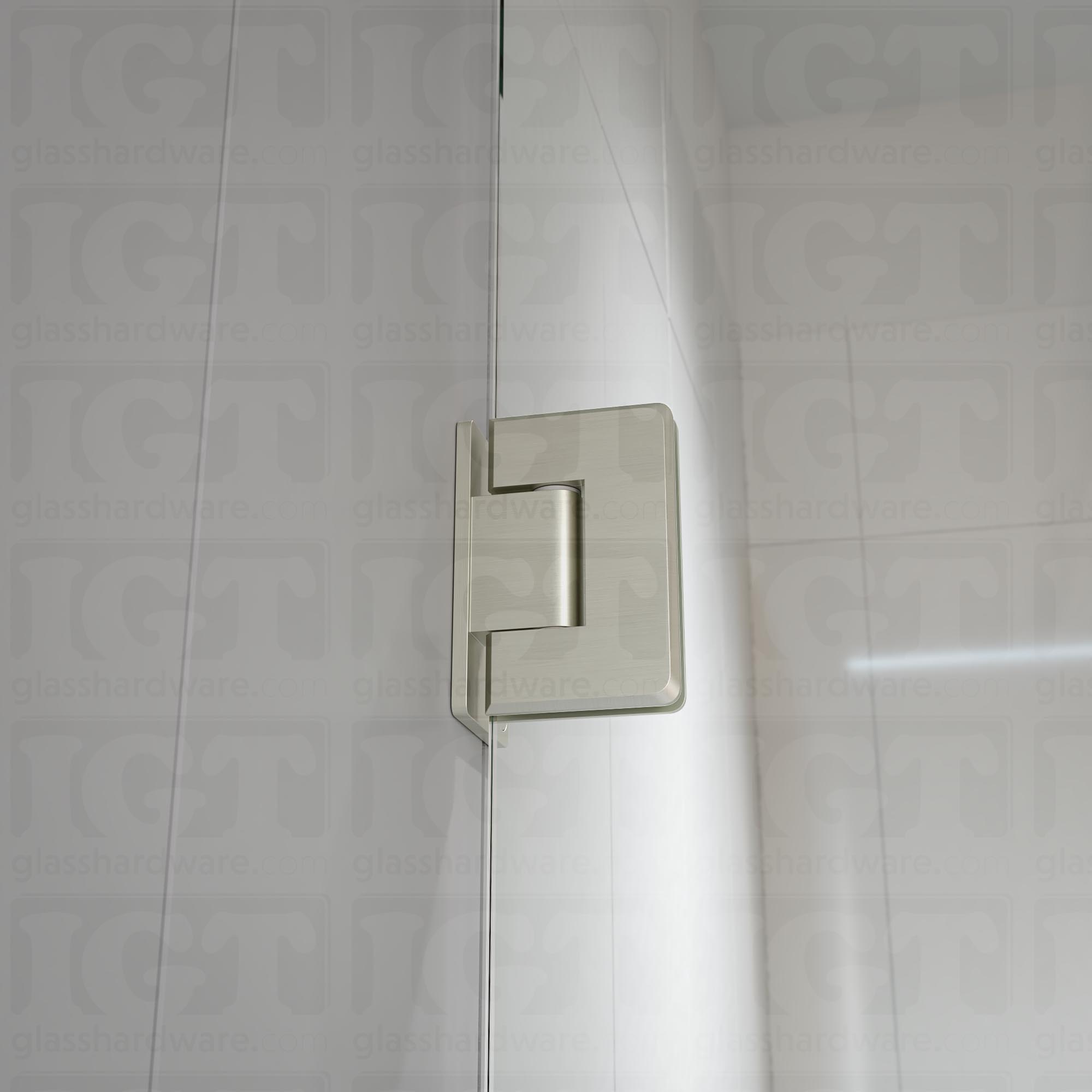 A close-up view of the Wall-to-Glass Offset Back Bilboa Hinge installed on a modern shower door, showcasing it's rounded corners and beveled edges. Brushed Nickel.