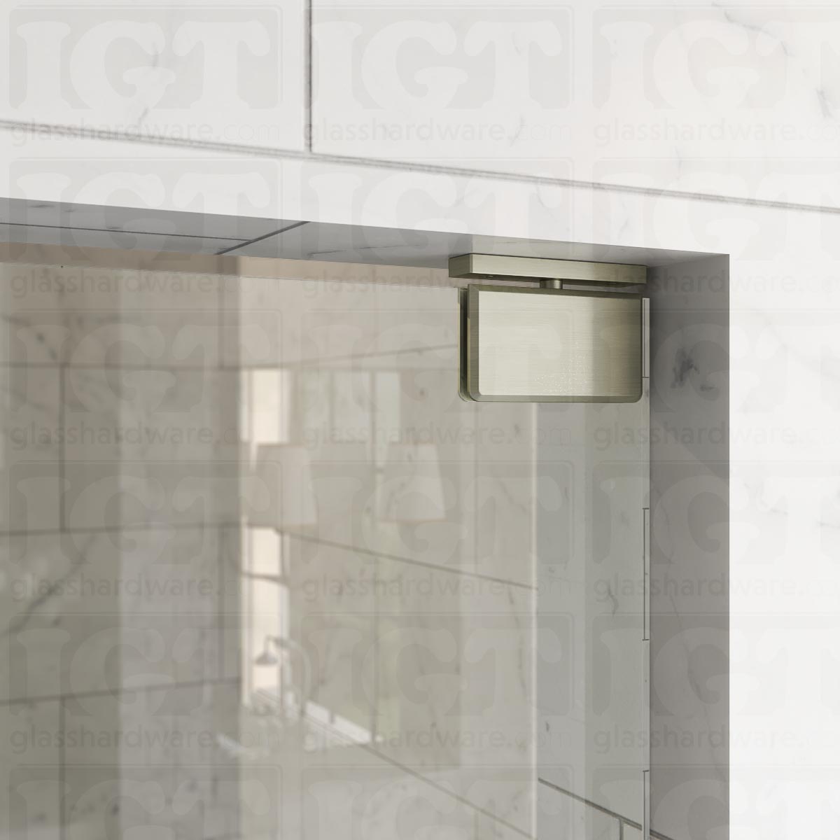 Close-up of the Top and Bottom Bilboa Pivot Hinge mounted at the top of the glass shower door, securing it to the tiled wall. The hinge has soft rounded corners and beveled edges, making it blend into the elegant bathroom setting. Brushed Nickel.