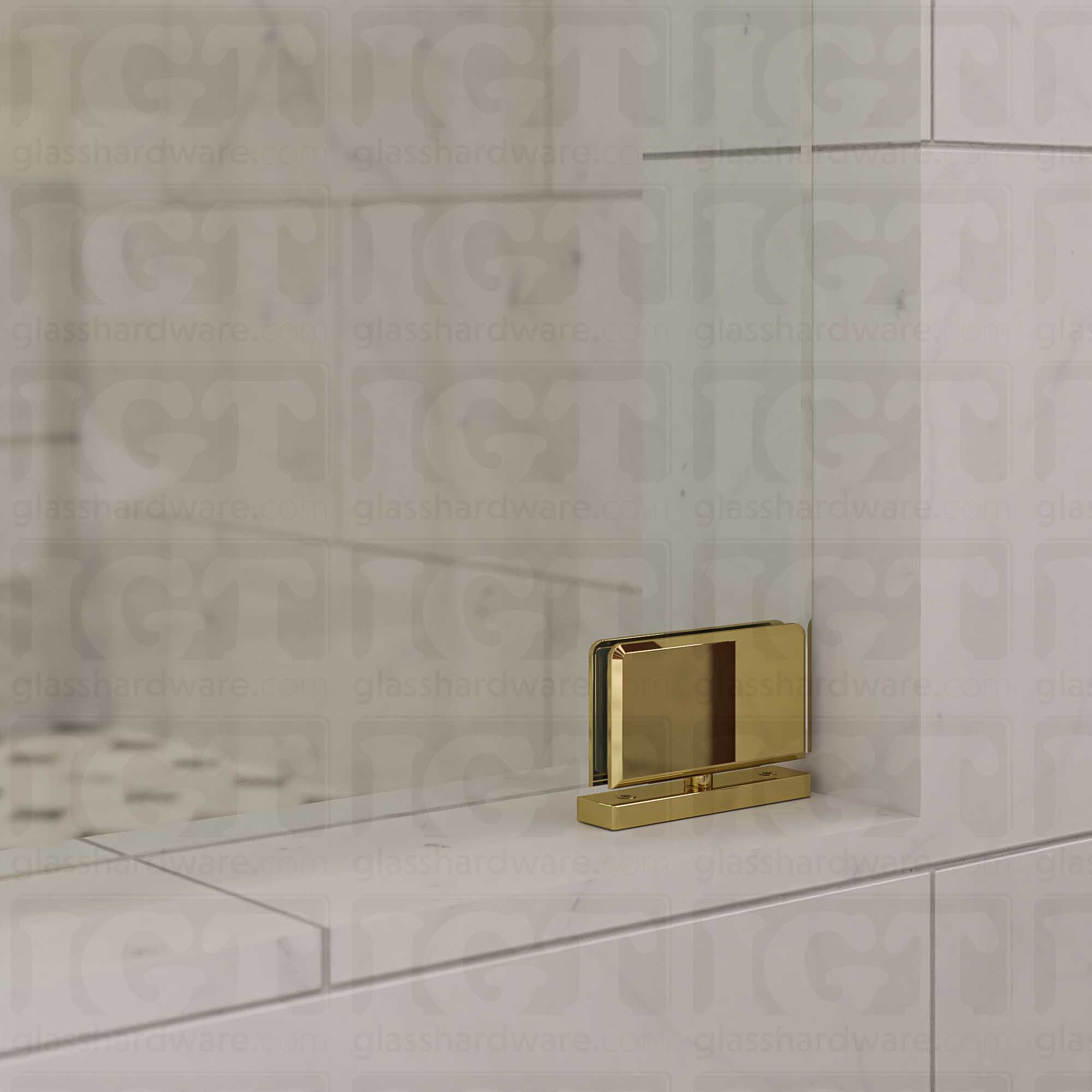 Close-up of a Top and Bottom Bilboa Pivot Hinge mounted at the bottom of the glass shower door, attaching it securely to the tiled threshold. Polished Brass.