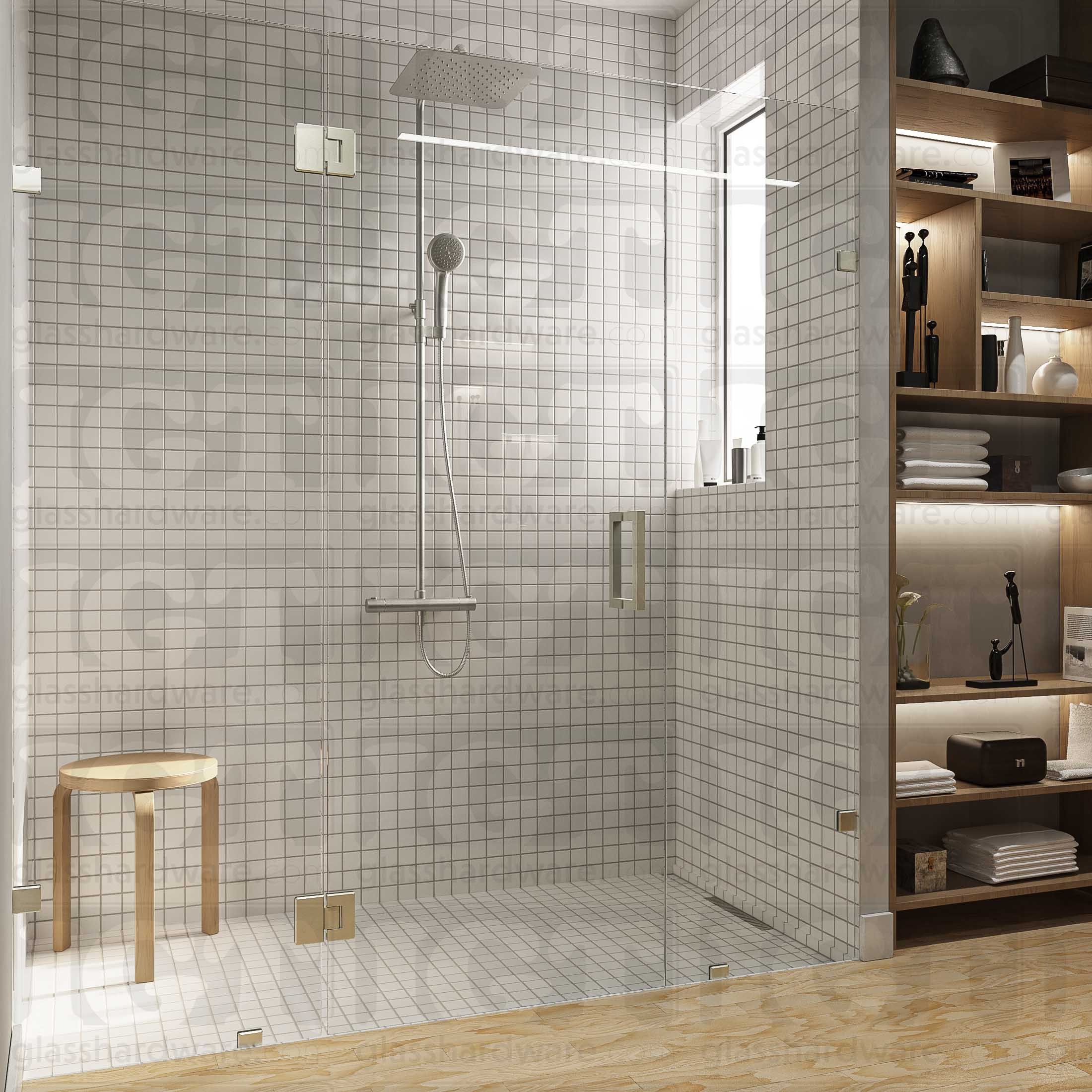 A modern bathroom with a frameless glass shower enclosure, fixed to the wall using Wall-to-Glass Bilboa Clamps. The shower's white tile walls complement the rest of the bathroom's light wood flooring and furnishings. Brushed Nickel.