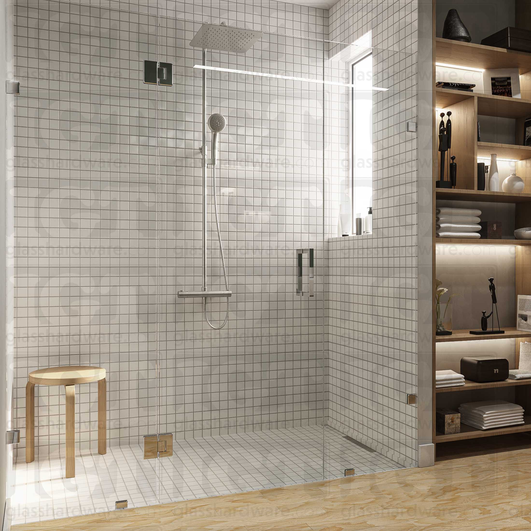 A modern bathroom with a frameless glass shower enclosure, fixed to the wall using Wall-to-Glass Bilboa Clamps. The shower's white tile walls complement the rest of the bathroom's light wood flooring and furnishings. Chrome Polished.