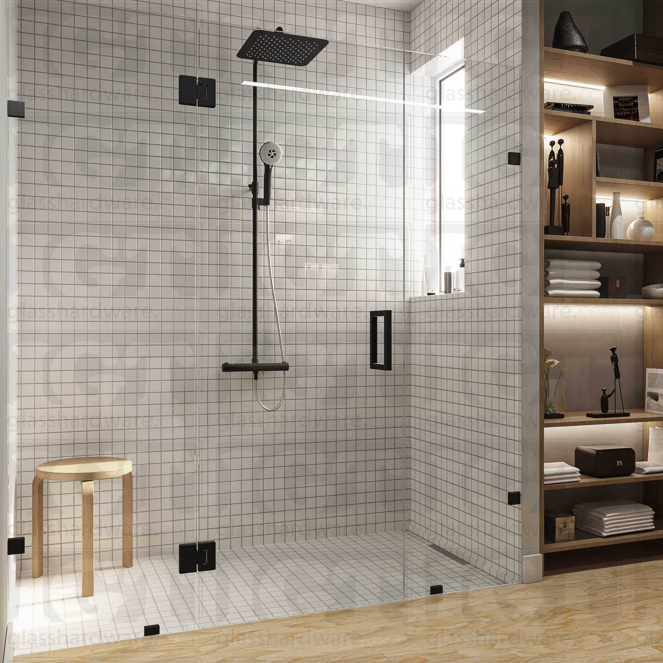 A modern bathroom with a frameless glass shower enclosure, fixed to the wall using Wall-to-Glass Bilboa Clamps. The shower's white tile walls complement the rest of the bathroom's light wood flooring and furnishings. Matte Black.