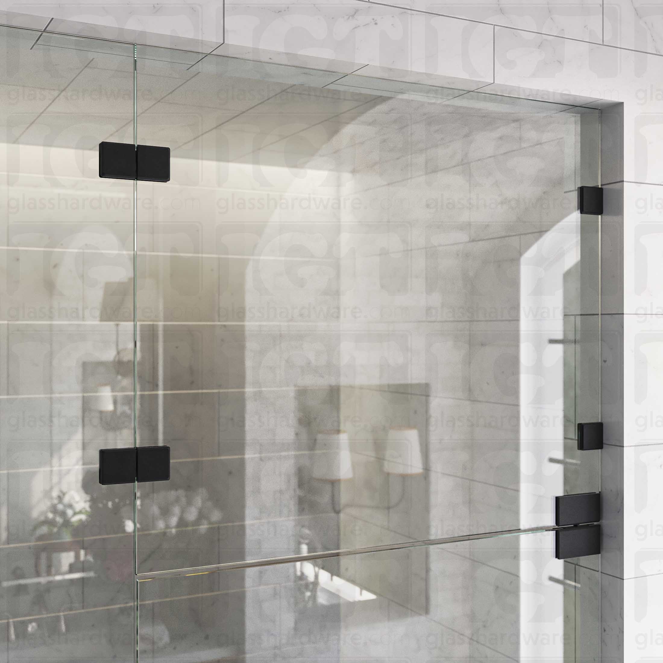 An upper view of the shower's glass panels, secured with Glass-to-Glass 180 Degree Bilboa Clamps (Split Face) alongside a matching hinge for the door. The hardware's corresponding finishes give the shower elegance and cohesiveness. Matte Black.