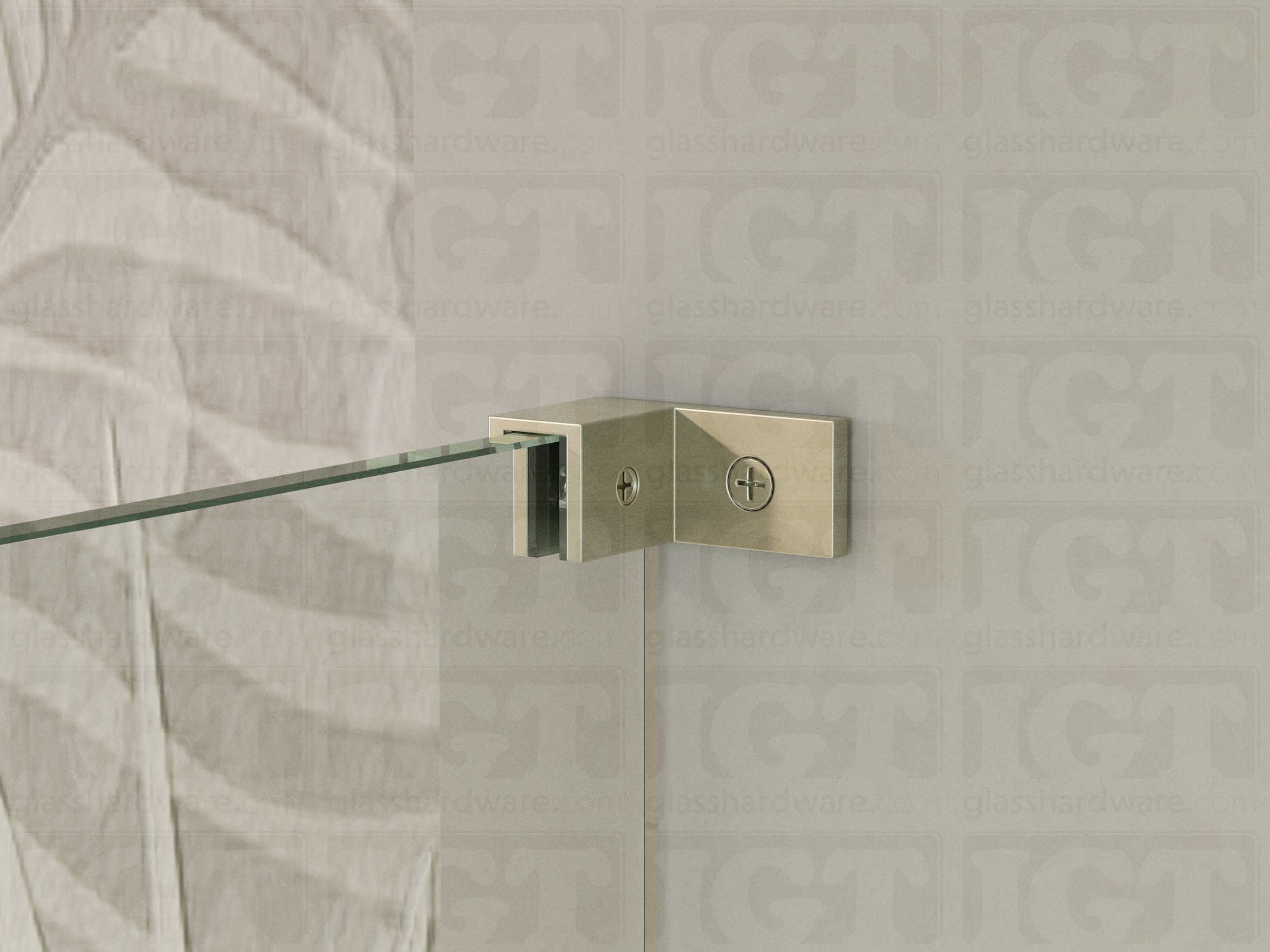 A close up of the Left Wall-to-Glass Sleeve Over Clamp installed on a frameless glass shower enclosure. The clamp is securely mounted to the shower's wall, providing additional support to the overall installation. Brushed Nickel.