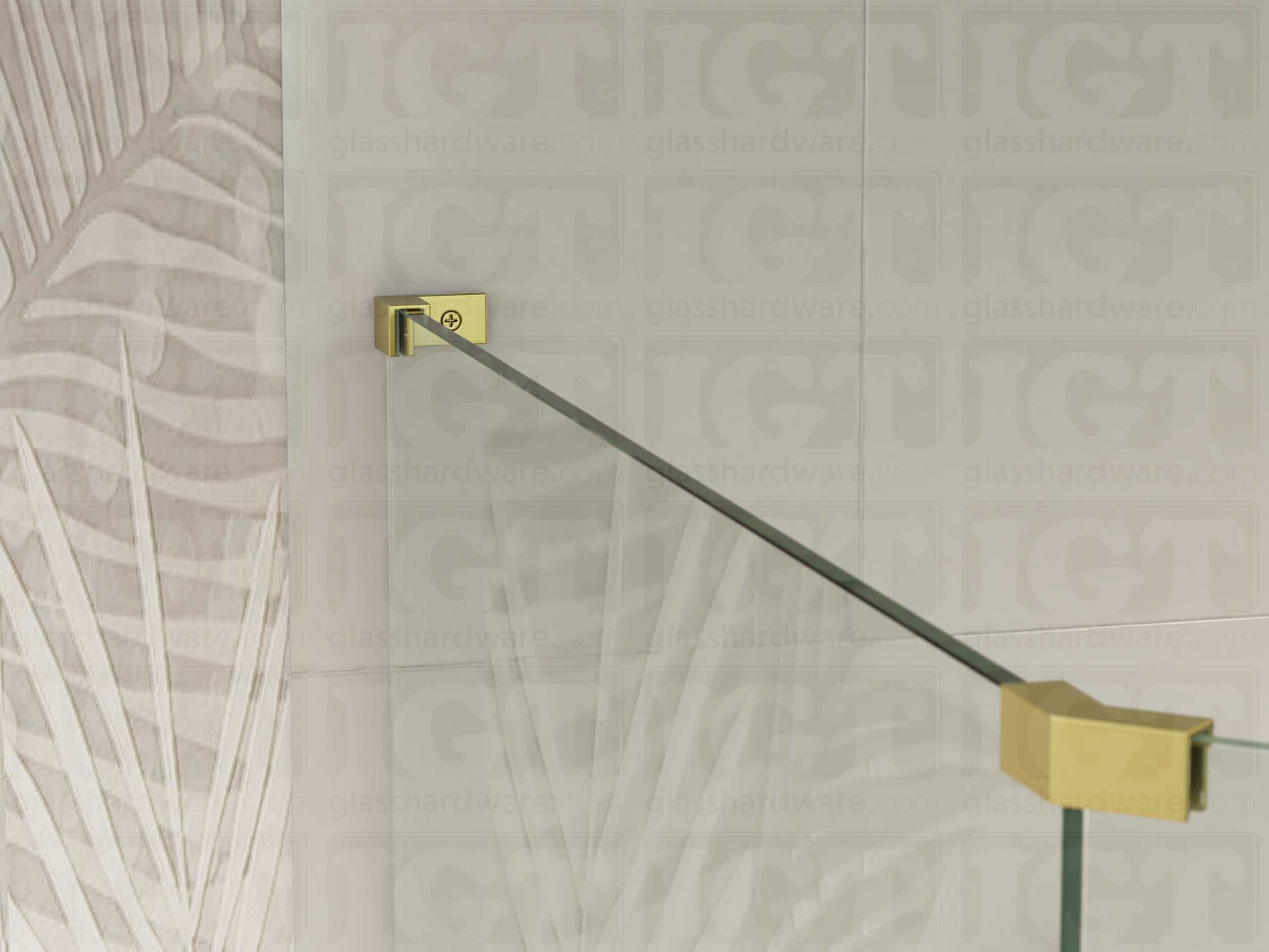 A view of the glass shower enclosure's upper section. The fixed panel is secured to the wall with a Left Wall-to-Glass Sleeve Over Clamp, and joined to an adjacent panel with a glass-to-glass clamp. Gold Brushed.