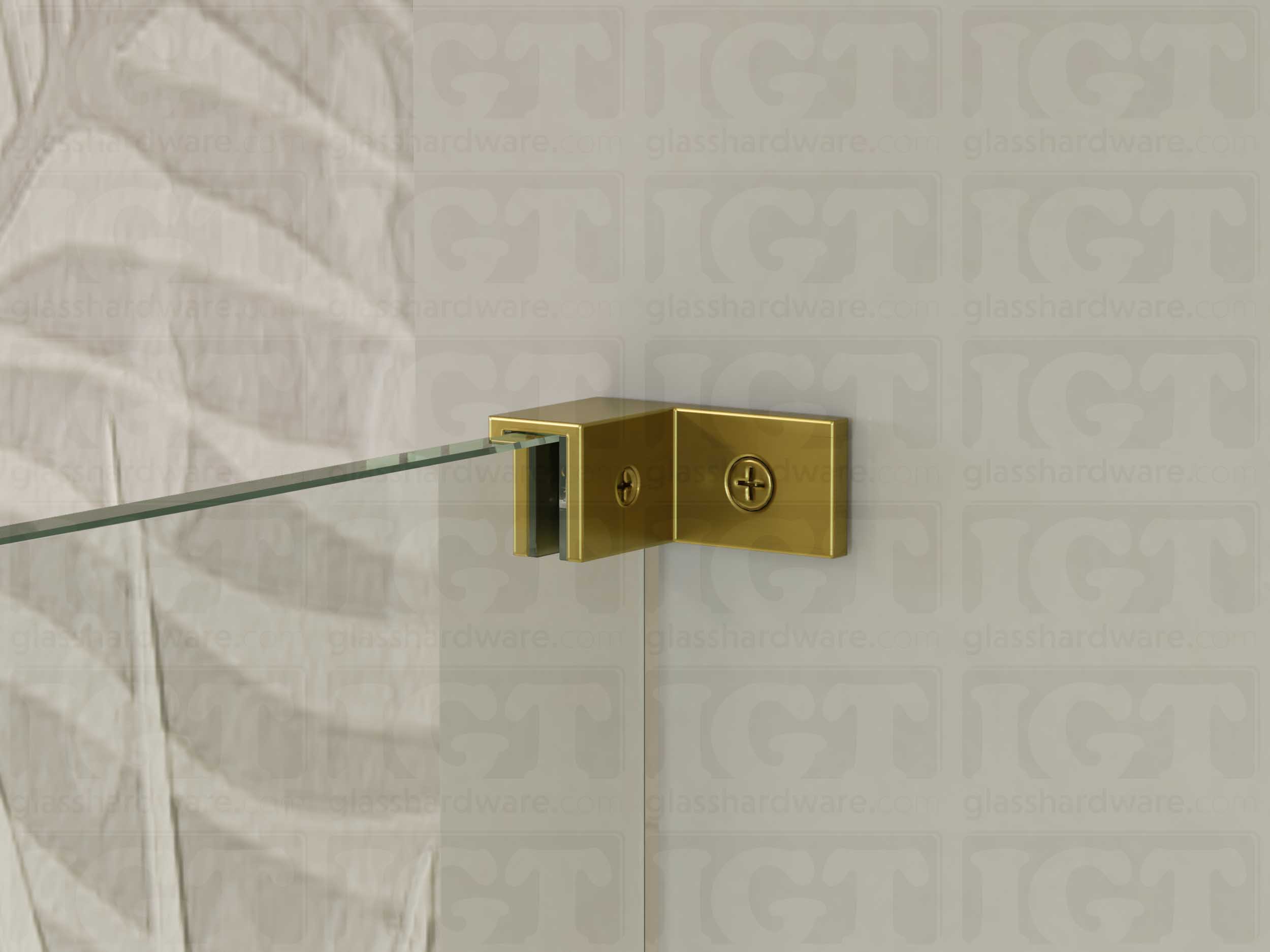 A close up of the Left Wall-to-Glass Sleeve Over Clamp installed on a frameless glass shower enclosure. The clamp is securely mounted to the shower's wall, providing additional support to the overall installation. Gold Brushed.