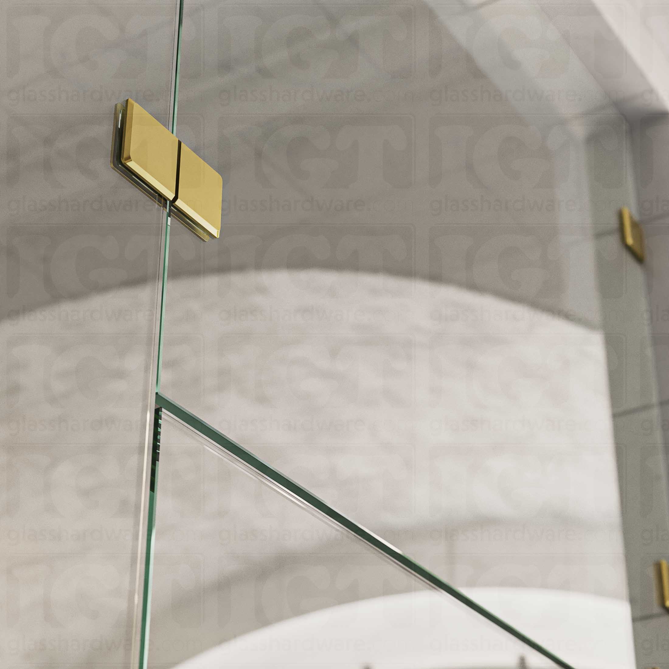 A close-up view of the Glass-to-Glass 180 Degree Bilboa Clamp (Split Face), installed on a frameless glass shower enclosure. The clamp's Solid Brass construction provides a secure and durable connection for the shower's panels. Gold Brushed.