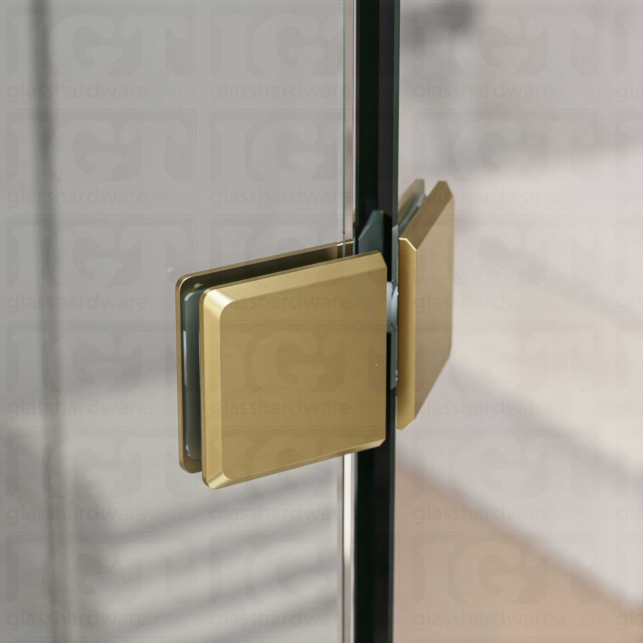 A close-up view of the Glass-to-Glass 135 Degree Bilboa Clamp, installed on a neo angle shower enclosure. The clamp's Solid Brass construction provides a secure and durable joint for the shower's angled panels. Gold Brushed.