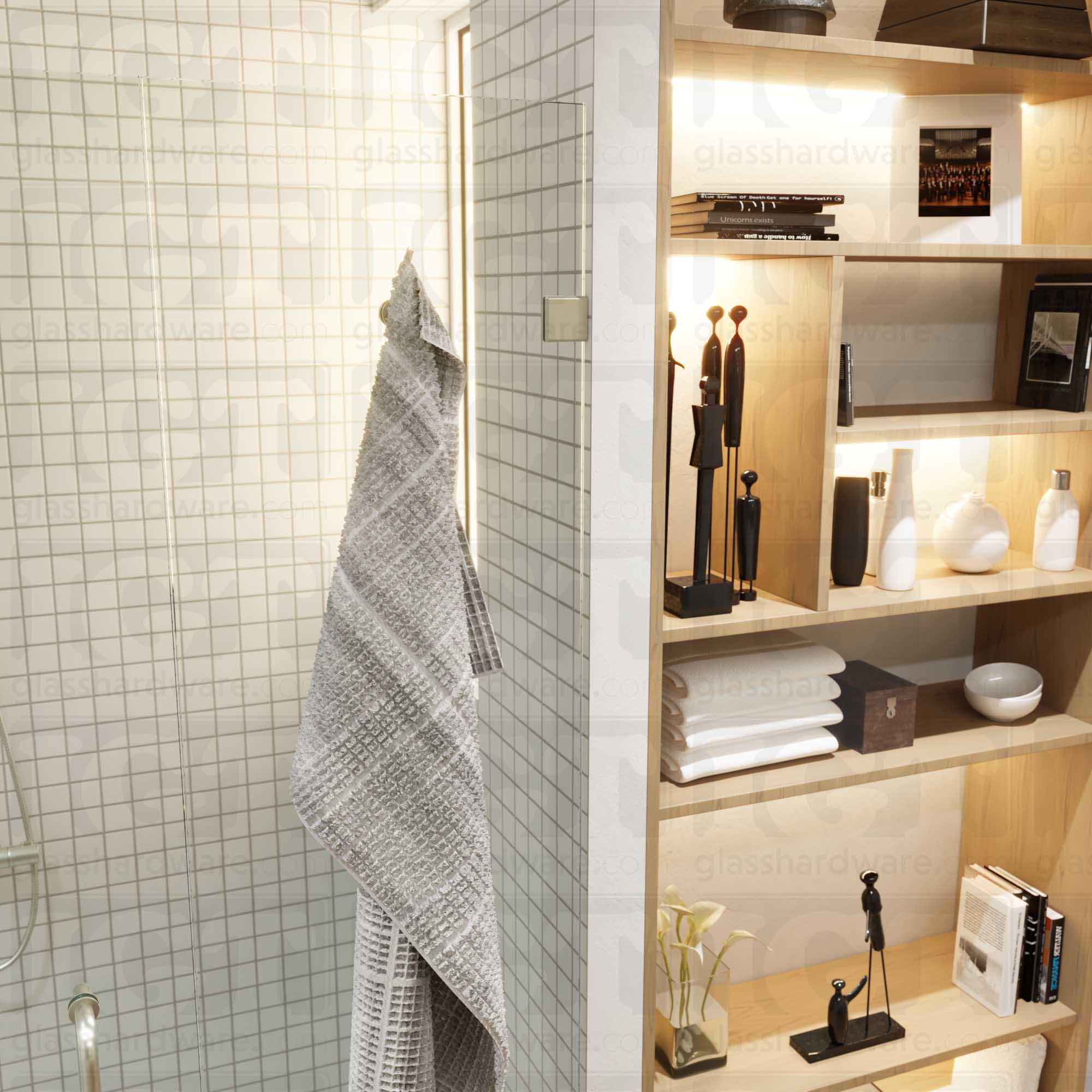 Close-up view of an Oversized Wall-to-Glass Bilboa Clamp mounted to the shower's white tile wall. The hinge's sleek beveled edges complements the bathroom's modern decor. Brushed Nickel.