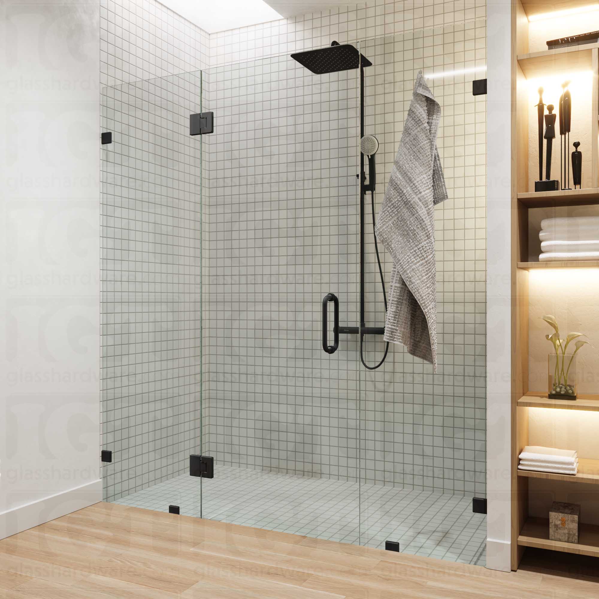 A modern bathroom with a frameless glass shower enclosure, fixed to the wall using Oversized Wall-to-Glass Bilboa Clamps. The shower's white tile walls complement the rest of the bathroom's light wood flooring and furnishings. Matte Black.