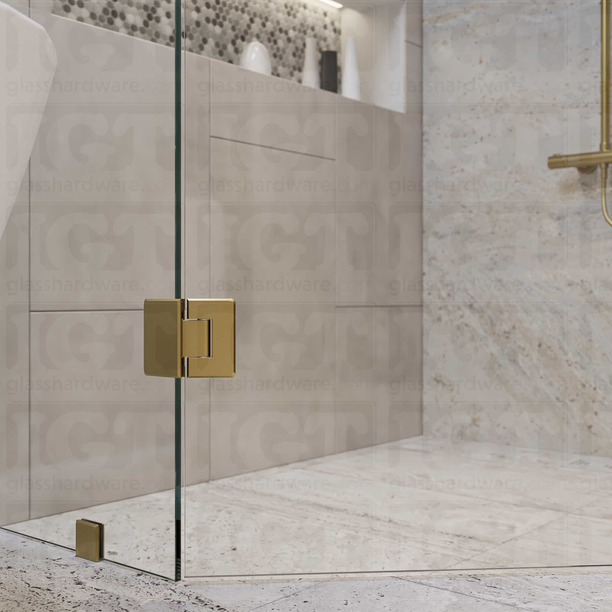 A close-up view of the top Glass-to-Glass 135 Degree Bilboa Hinge installed on a modern shower door, showcasing how the hinge securely holds the adjacent glass panels. Gold Brushed.