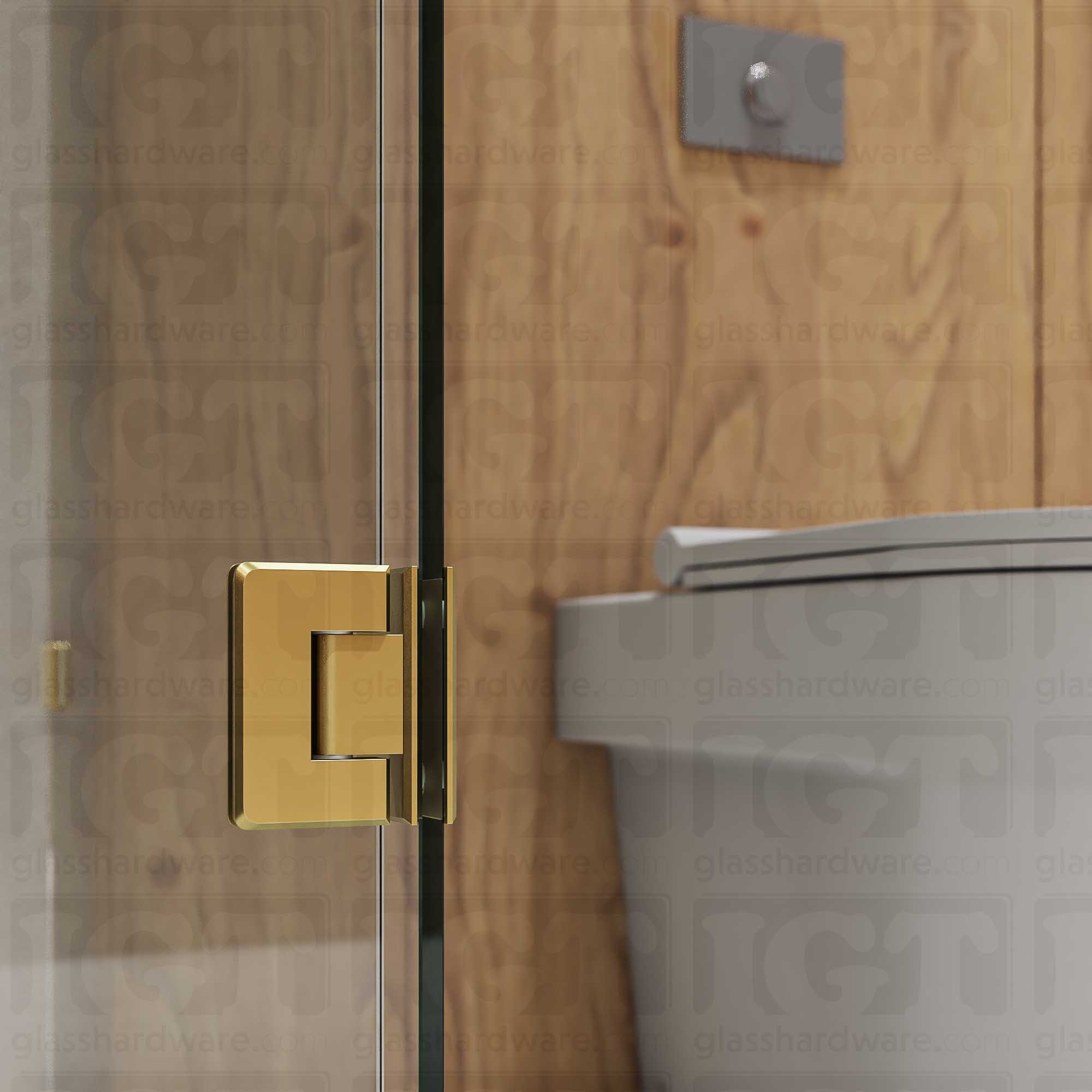 A close-up view of the bottom Glass-to-Glass 90 Degree Bilboa Hinge installed on a modern shower door, showcasing its beveled-edge design in more detail. Gold Brushed.