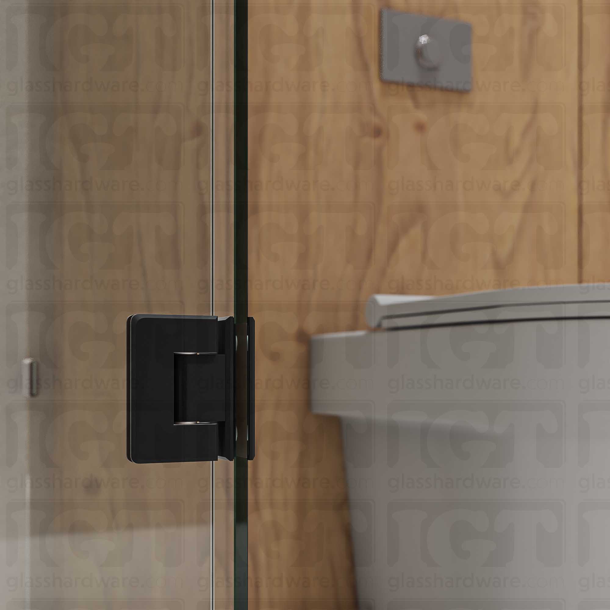 A close-up view of the bottom Glass-to-Glass 90 Degree Bilboa Hinge installed on a modern shower door, showcasing its beveled-edge design in more detail. Matte Black.