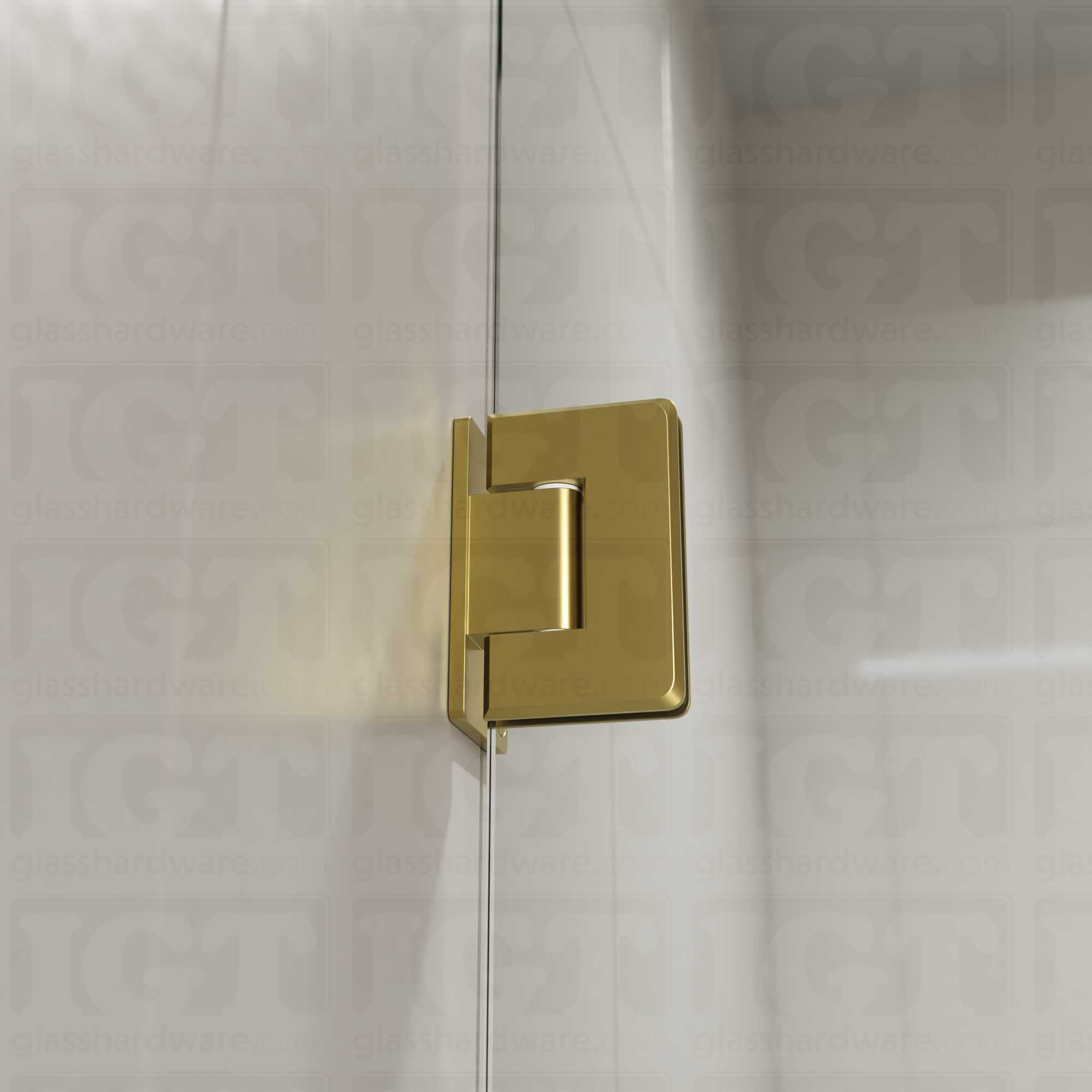 A close-up view of the Wall-to-Glass Offset Back Bilboa Hinge installed on a modern shower door, showcasing it's rounded corners and beveled edges. Gold Brushed.