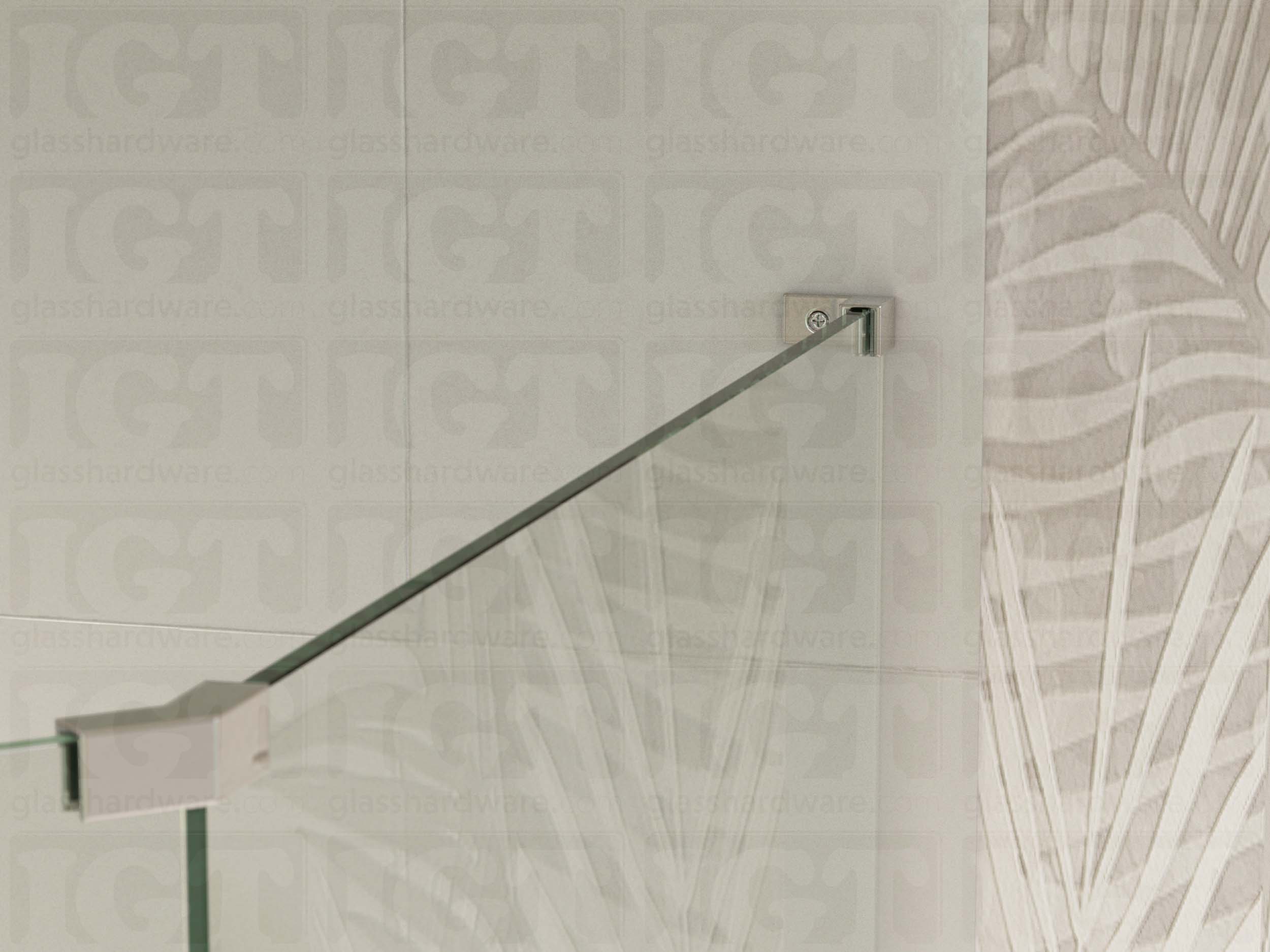 A view of the glass shower enclosure's upper section. The fixed panel is secured to the wall with a Right Wall-to-Glass Sleeve Over Clamp, and joined to an adjacent panel with a glass-to-glass clamp. Chrome Polished.