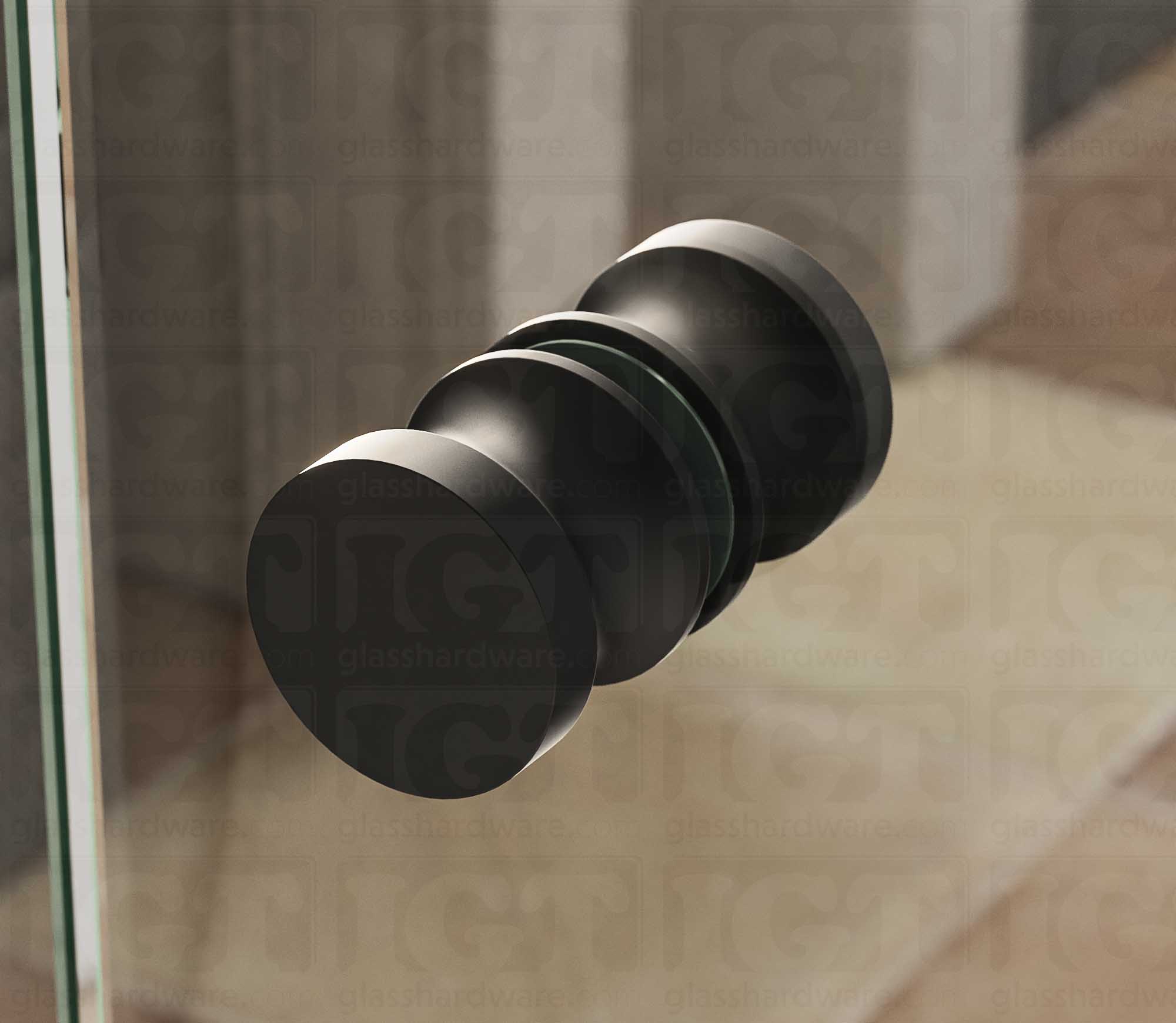 A close up of the European Style Back-to-Back Door Knob installed on a glass shower door. Soft natural light highlights the knob's Matte Black finish.