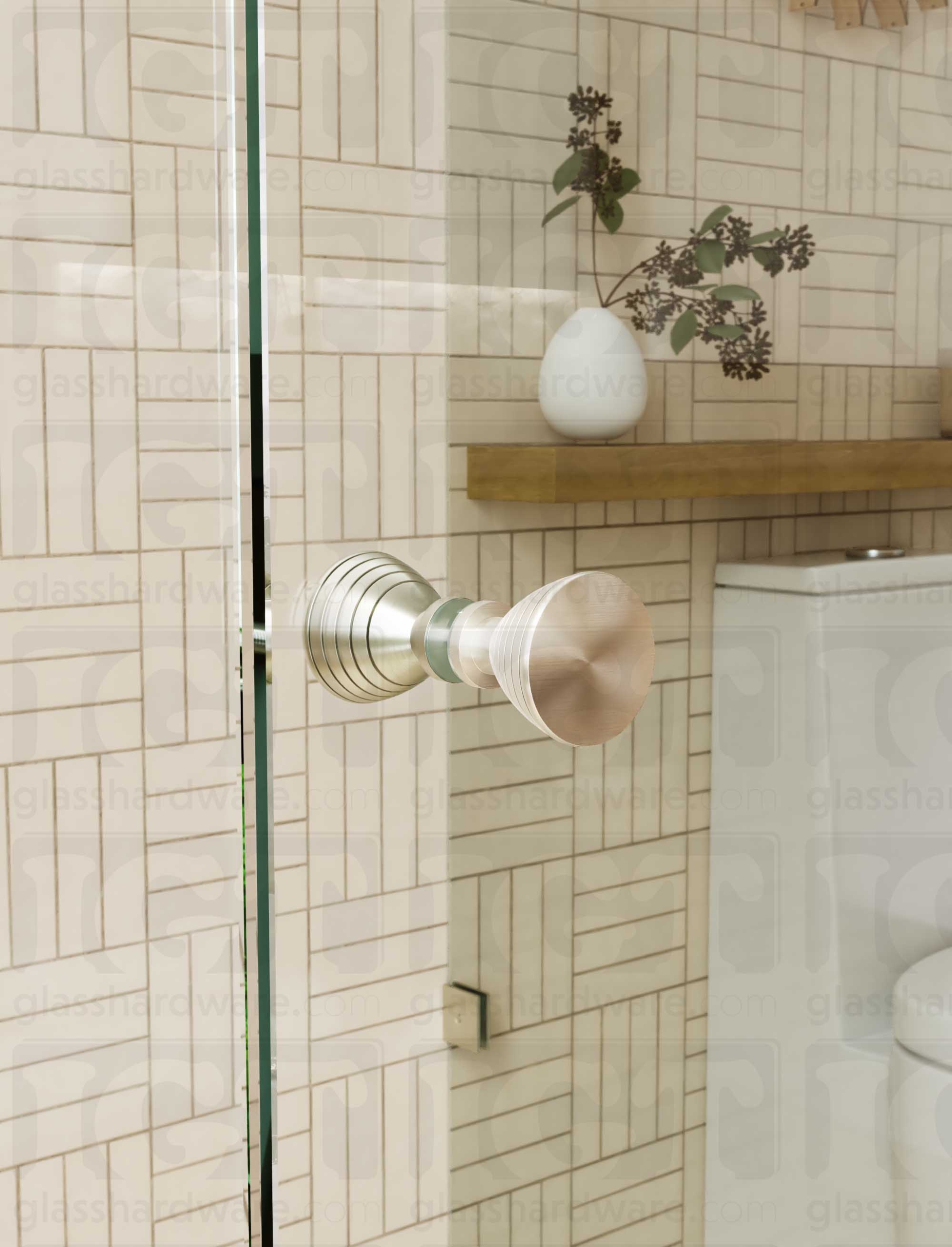 A close up of the Ribbed Bow Tie Style Back-to-Back Door Knob installed on a glass shower door. The door knob's back-to-back design is tightly secured to the glass door. Brushed Nickel.