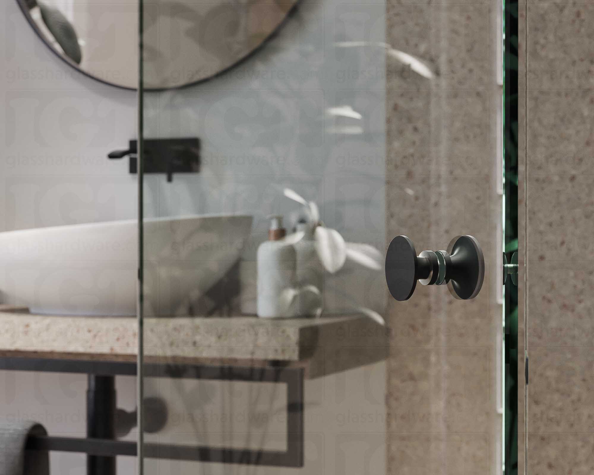 A close up of the Traditional Style Back-to-Back Door Knob installed on a glass shower door. The door knob's back-to-back design is tightly secured to the glass door. Matte Black.