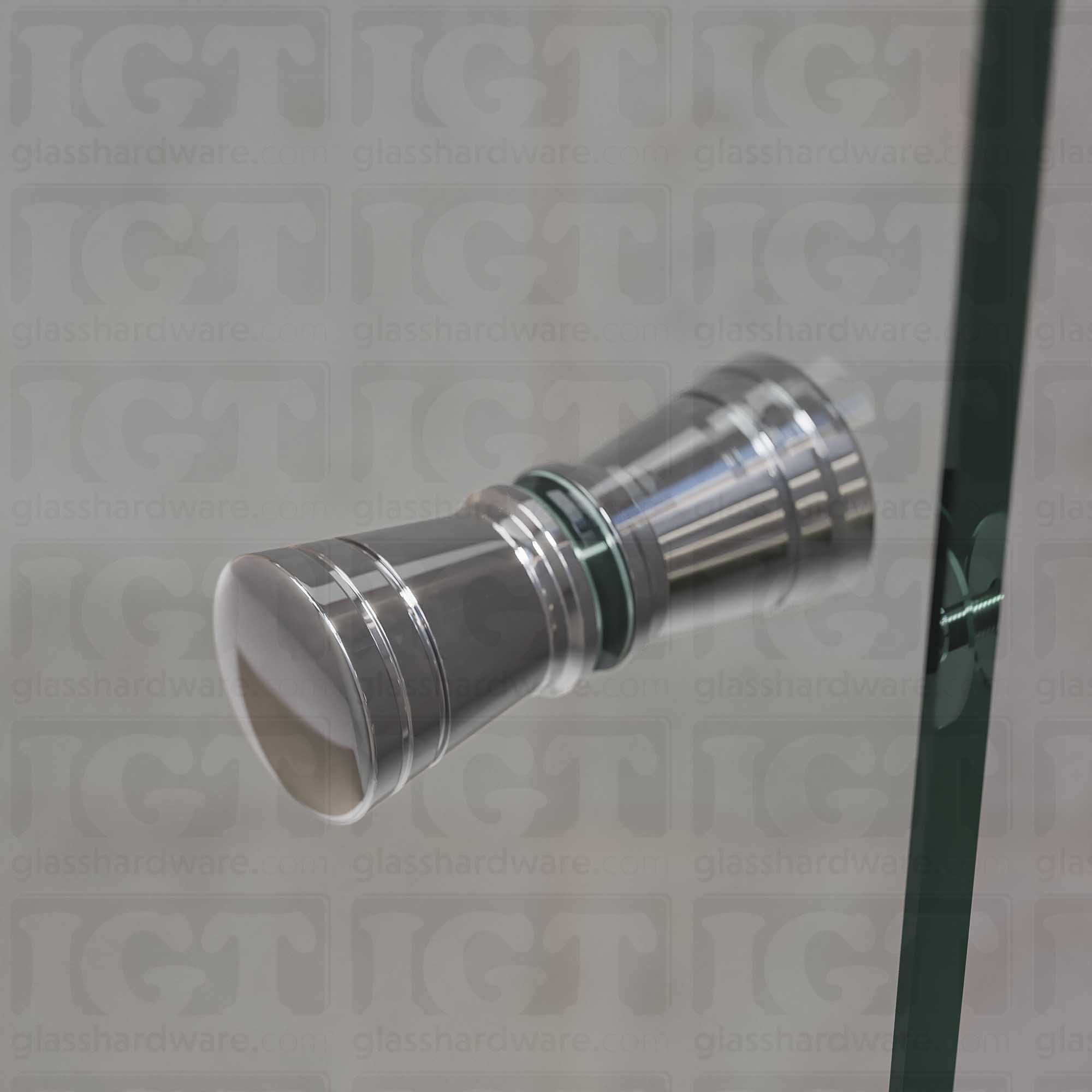 A close up of the Modern Ribbed Bow Tie Back-to-Back Door Knob installed on a glass shower door. Soft ambient light highlights the knob's Chrome Polished finish.