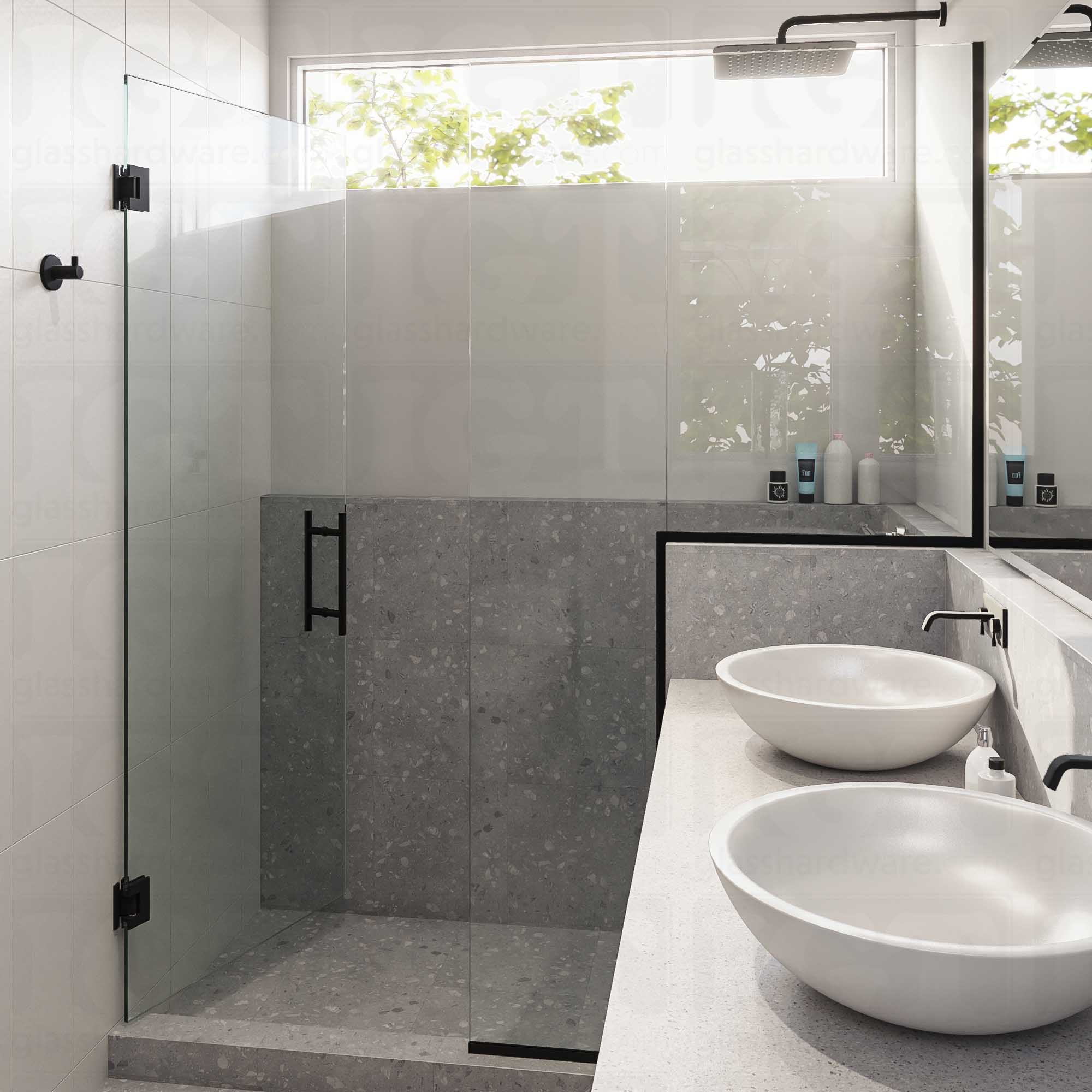 A modern bathroom with a semi-frameless glass shower enclosure featuring the 8" Center-to-Center Round Ladder Handle. Matte Black.