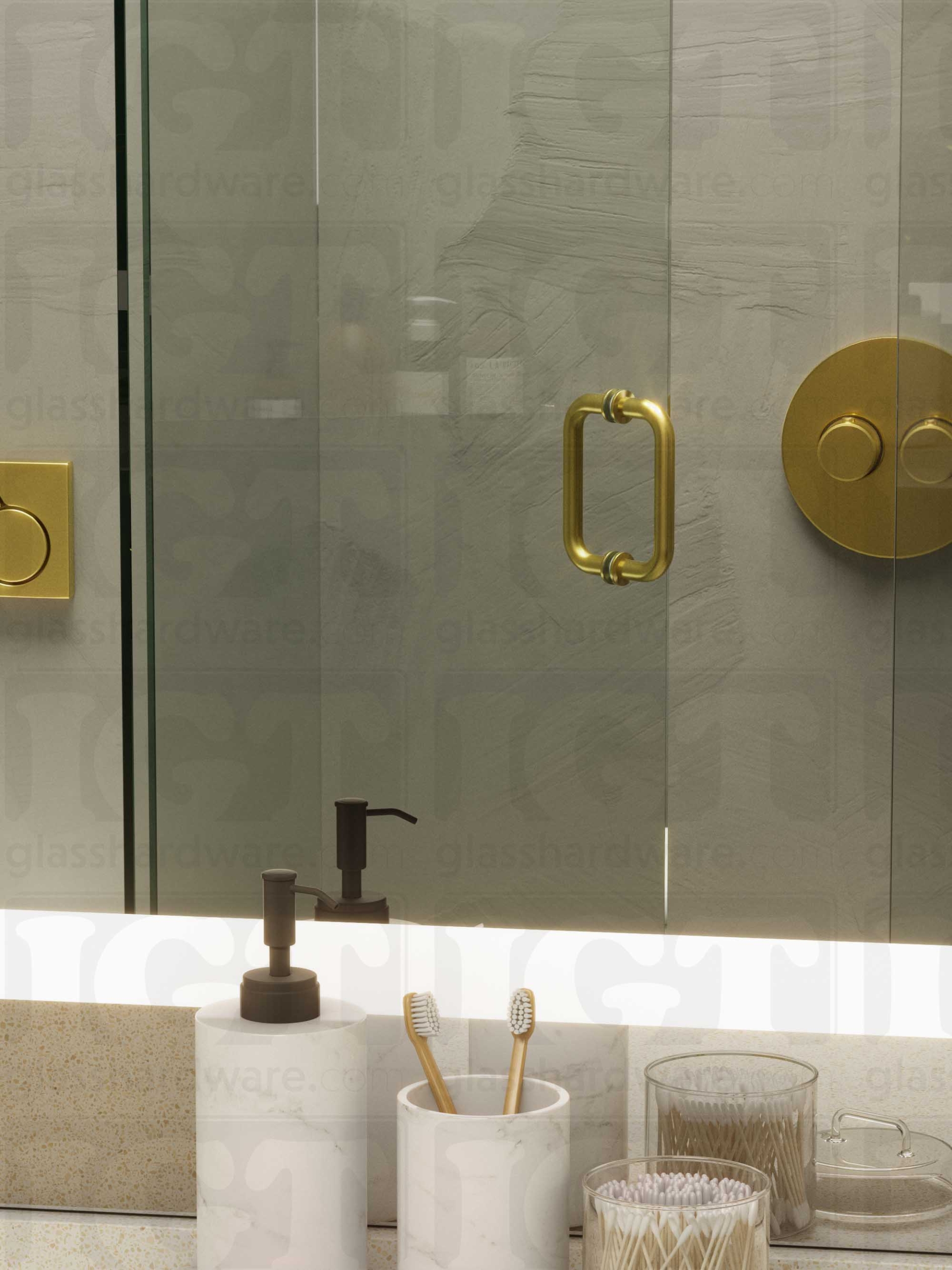 A frameless glass shower door in the open position, featuring the 6" Round Pull Handle. Gold Brushed.