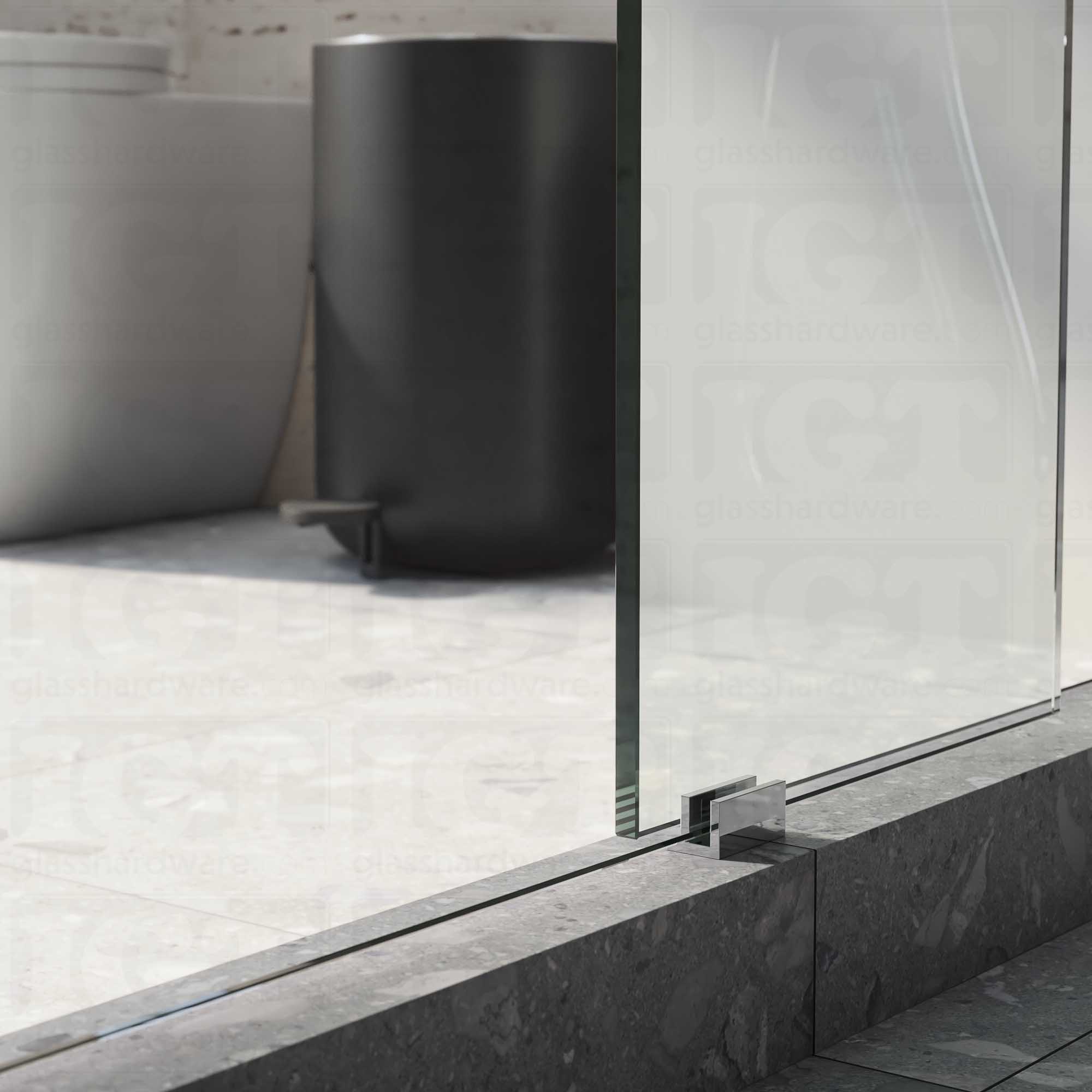 A close up of the Floor Guide for Modern Sliding System installed at the base of a glass sliding door. Chrome Polished.